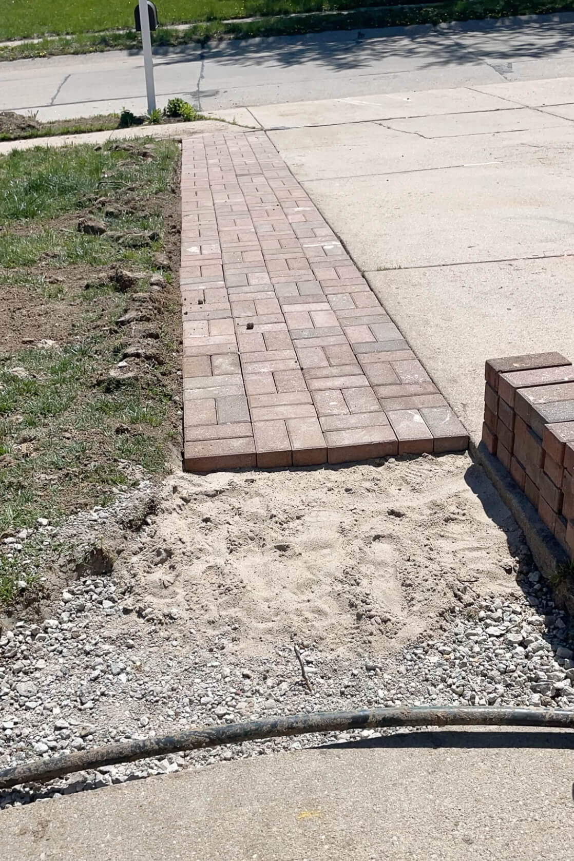 DIY paver driveway extension progress photo.